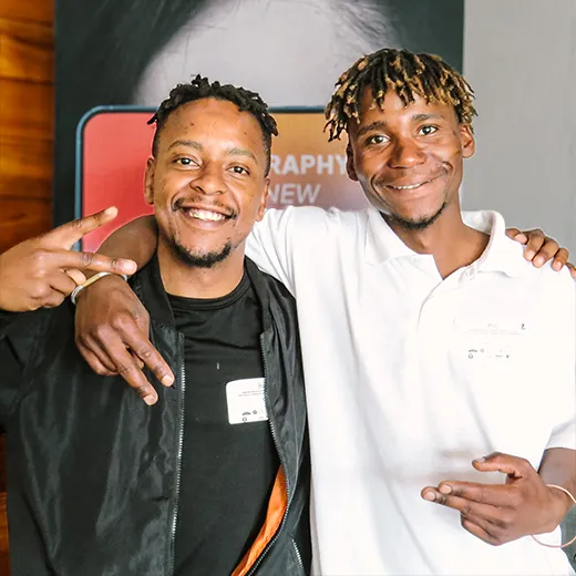 Two men standing indoors, smiling for a picture.
