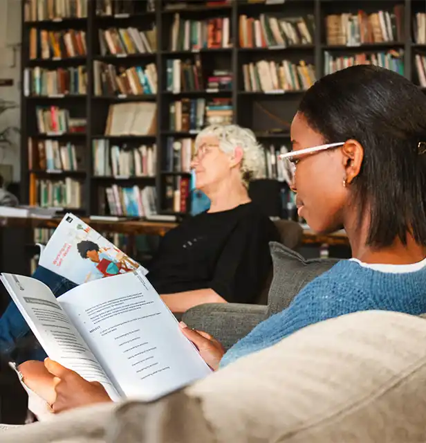 Two people sitting together with workbooks during a recovery programme session.