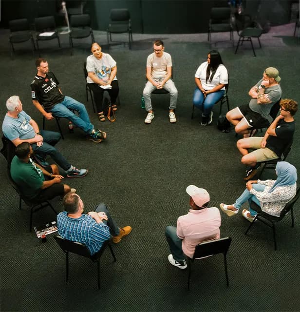 A top-down view of a recovery group seated in a circle.